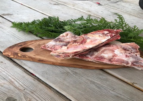 Fresh beef dog bones on a cutting board 
